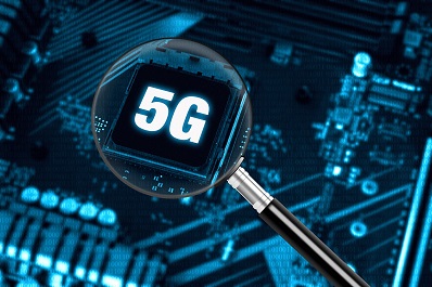 The concept of 5G network with magnifying glass on modern circuit board, high-speed mobile internet and new generation networks technology background
